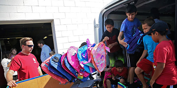 children helping to move items inside a truck